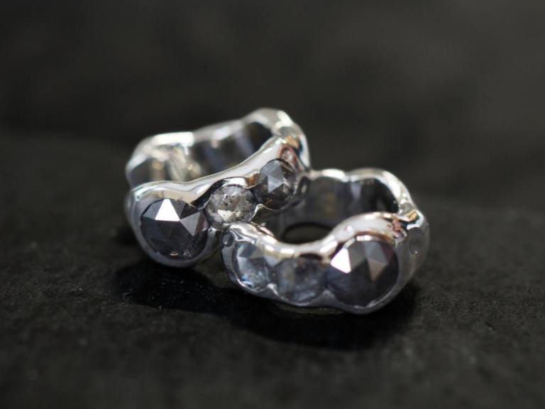 Close-up of two crafted wedding bands with a shared engraving detail, Singapore atelier